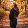 Frau im schwarzen Premium Black Rose Design Hoodie mit Rosenmotiv im herbstlichen Wald