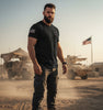 Mann trägt weiches Unisex T-Shirt mit amerikanischer Flagge vor Militärfahrzeugen und Flagge
